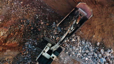 toma superior de la excavadora colocando arena o escombros en un camión
