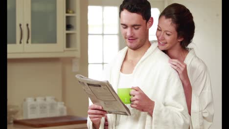 una pareja feliz leyendo el periódico juntos