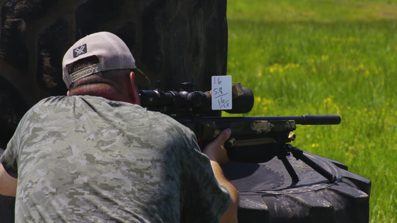Skilled Sharpshooter Aiming Rifle With Handwritten Scoring At Shooting Range In Leach, Oklahoma