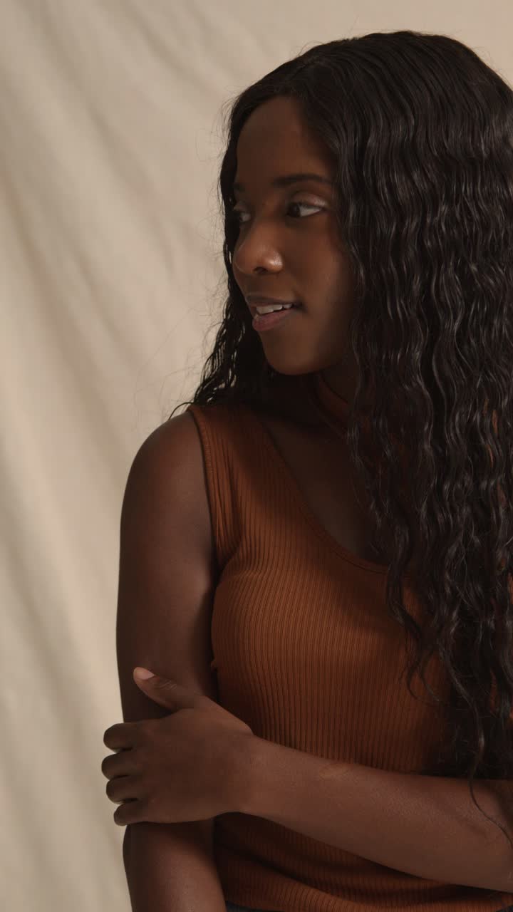 студийный портрет молодой женщины, чувствующей мягкость кожи после использования продукта красоты