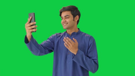 happy indian man talking with someone on video call green screen