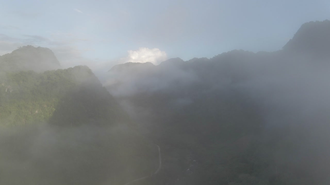 무인 항공기는 안개 낀 산맥을 드러내기 위해 구름을 통해 날아갑니다.