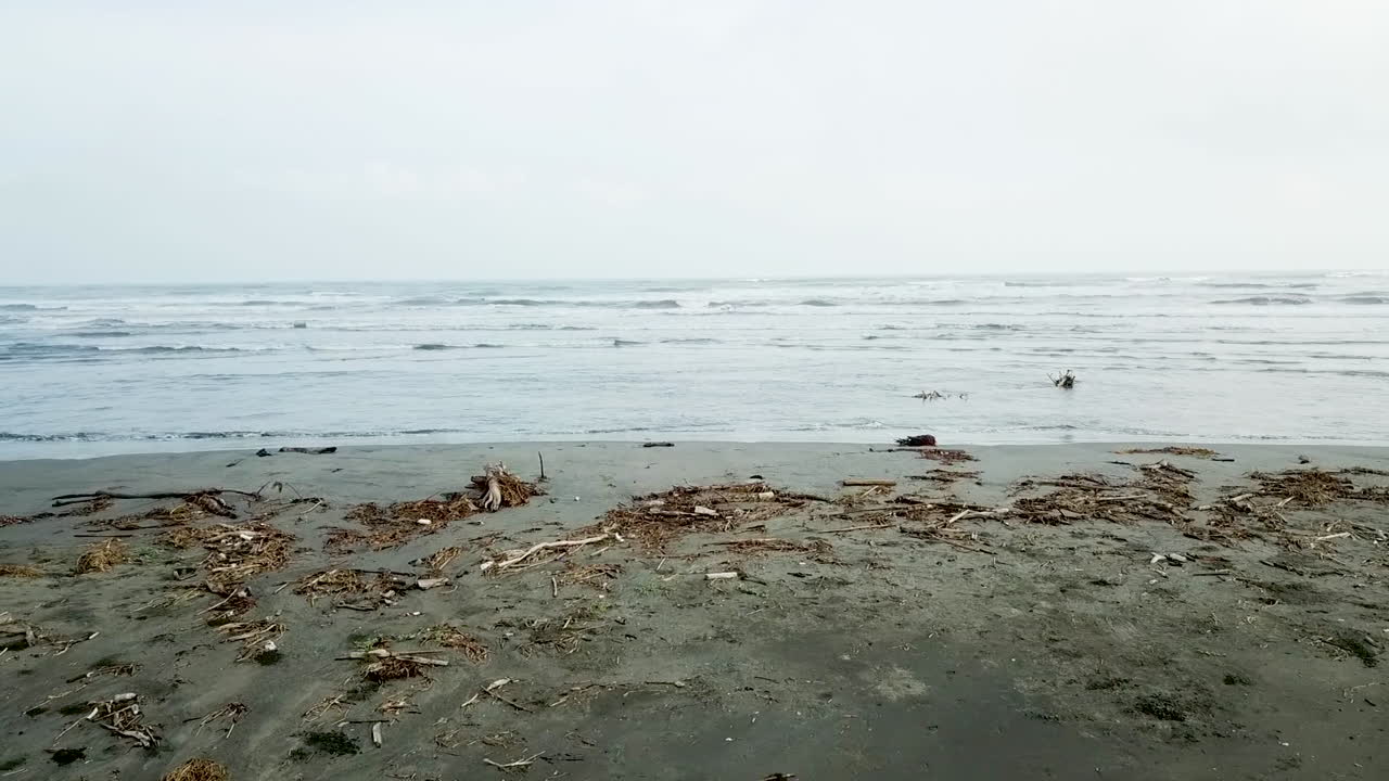 모래와 바다가 있는 남미 해변 위로 느리고 낮게 날아가는 드론 샷