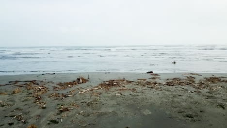 drone shot flying slow and low over a south american beach with sand and ocean