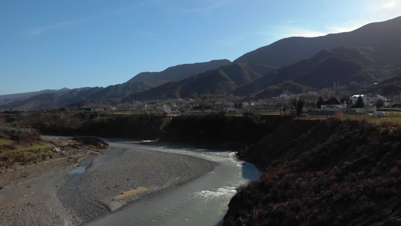 río con agua corriente en el paisaje campestre, colinas y montañas de fondo en los balcanes
