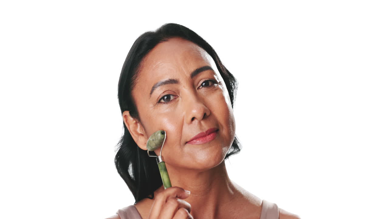 Middle-Aged Woman Using Jade Roller for Facial Massage