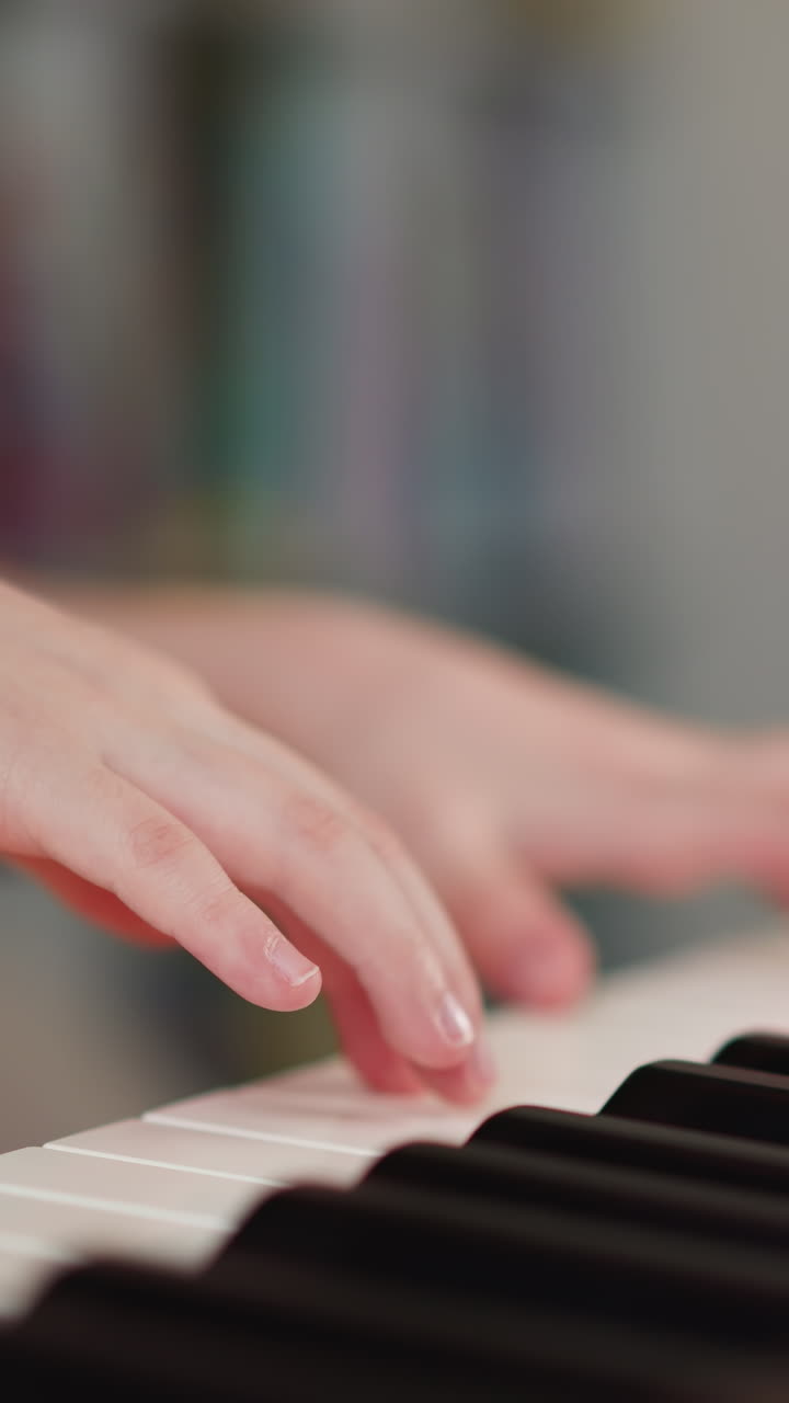 Girl hands press keys on keyboard of musical instrument. Child performs expressive melody on synthesizer. Little musician practices at home closeup on blurred background