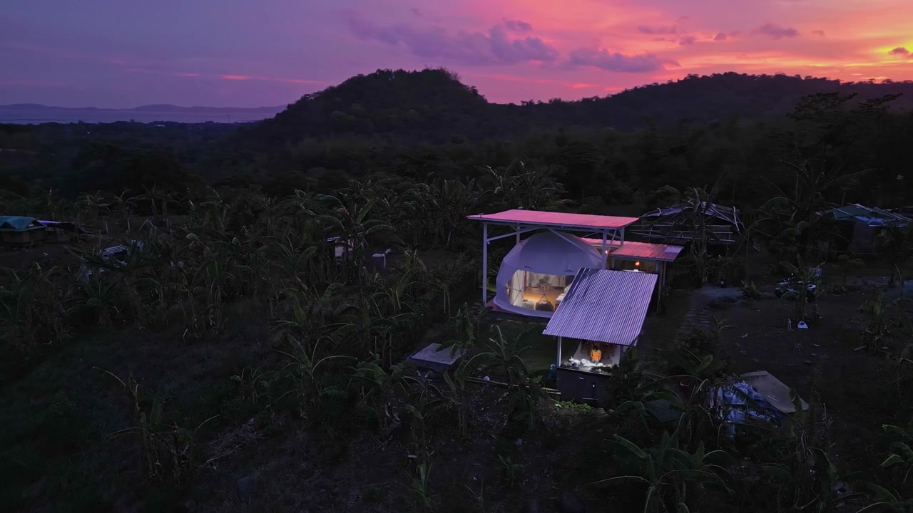 Vista aerea al tramonto di un Airbnb a cupola a Tanay, Rizal, vicino al fiume Pililla, con luce dorata sulle montagne di Luzon orientale.