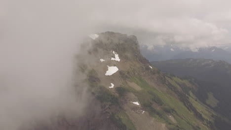 un vuelo lento hacia la cima de una montaña mientras las nubes se despejan del camino