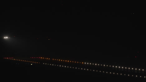 wide shot - airplane landing at night