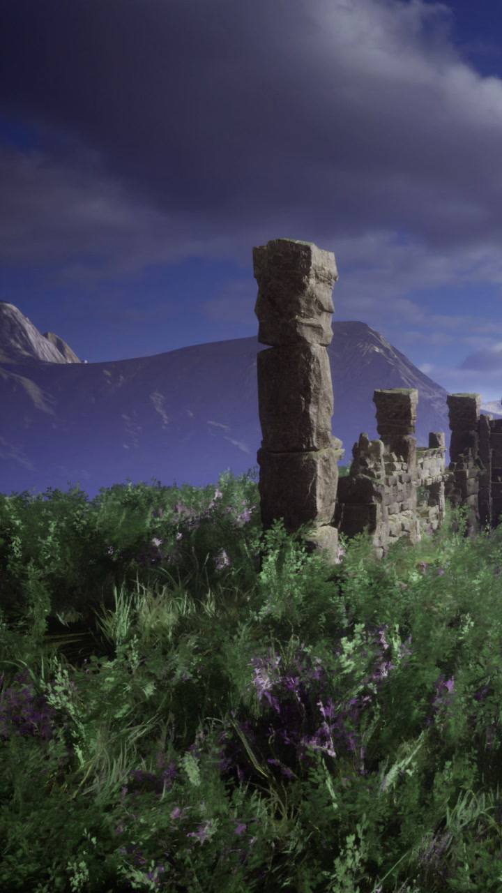 Old stone structure stands in green field with mountains in background