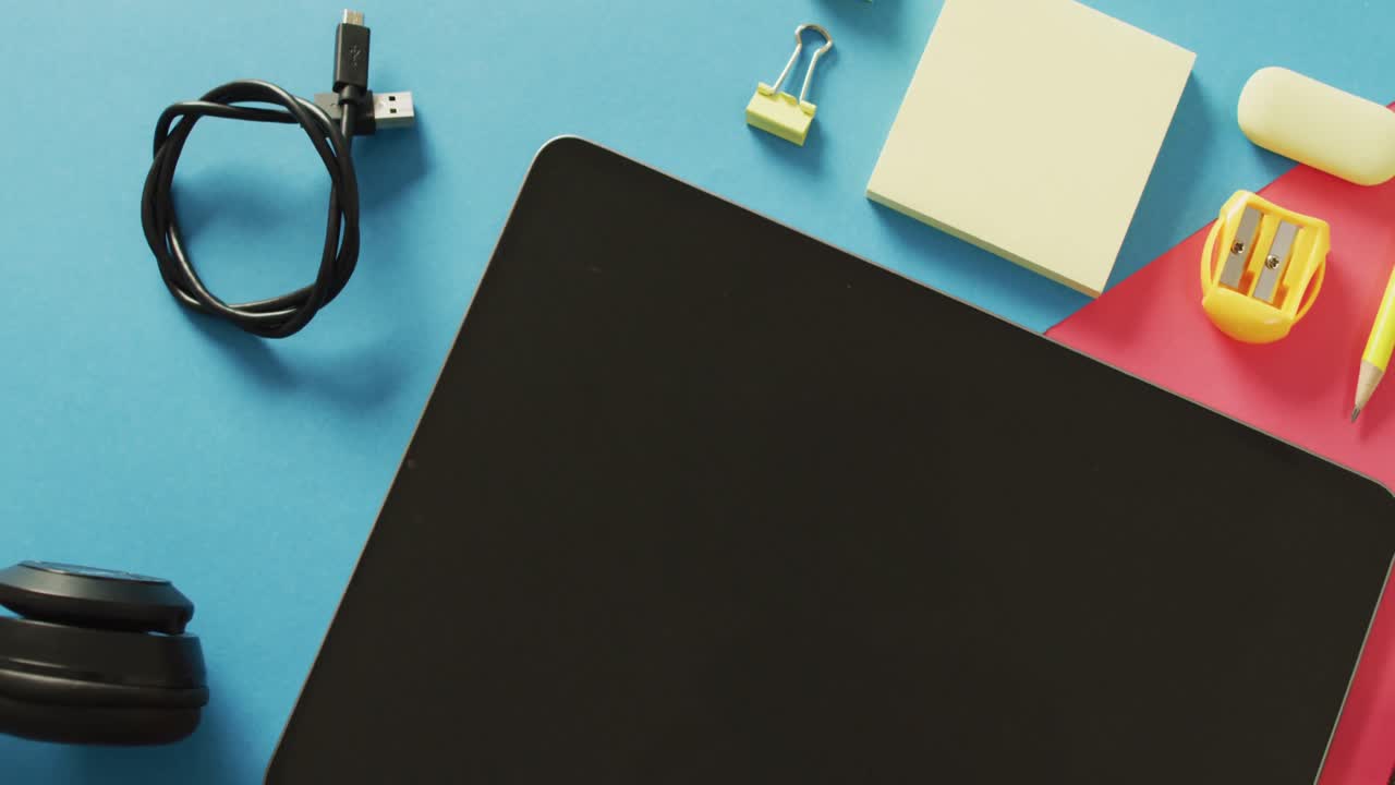 video de composición de artículos escolares y tableta con espacio de copia en superficie azul y rosa