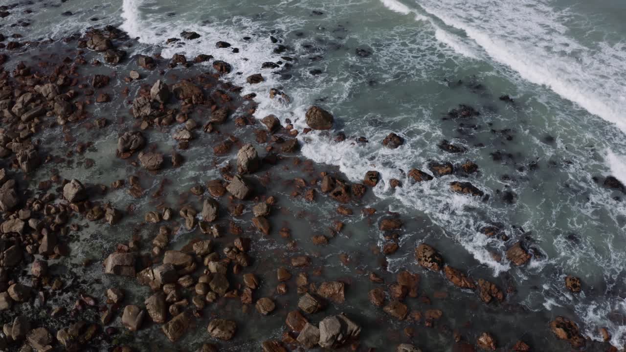 Onde che si infrangono dolcemente sulla costa rocciosa 4K