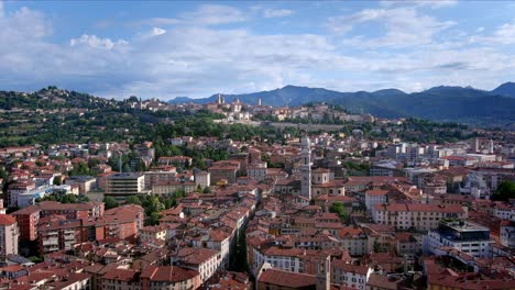 Italy,-Lombardy,-Bergamo-an-aerial-travel-from-the-ancient-medieval-upper-village-of-Bergamo-Alta-over-Bergamo-bassa-new-city