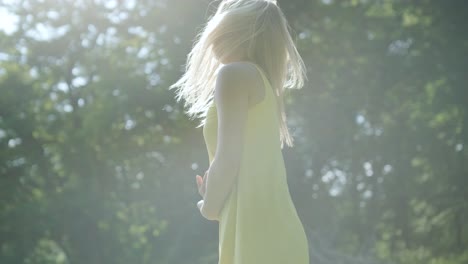 노란색 드레스를 입은 여자가 여름 공원에서 우아하게 춤을 춘다
