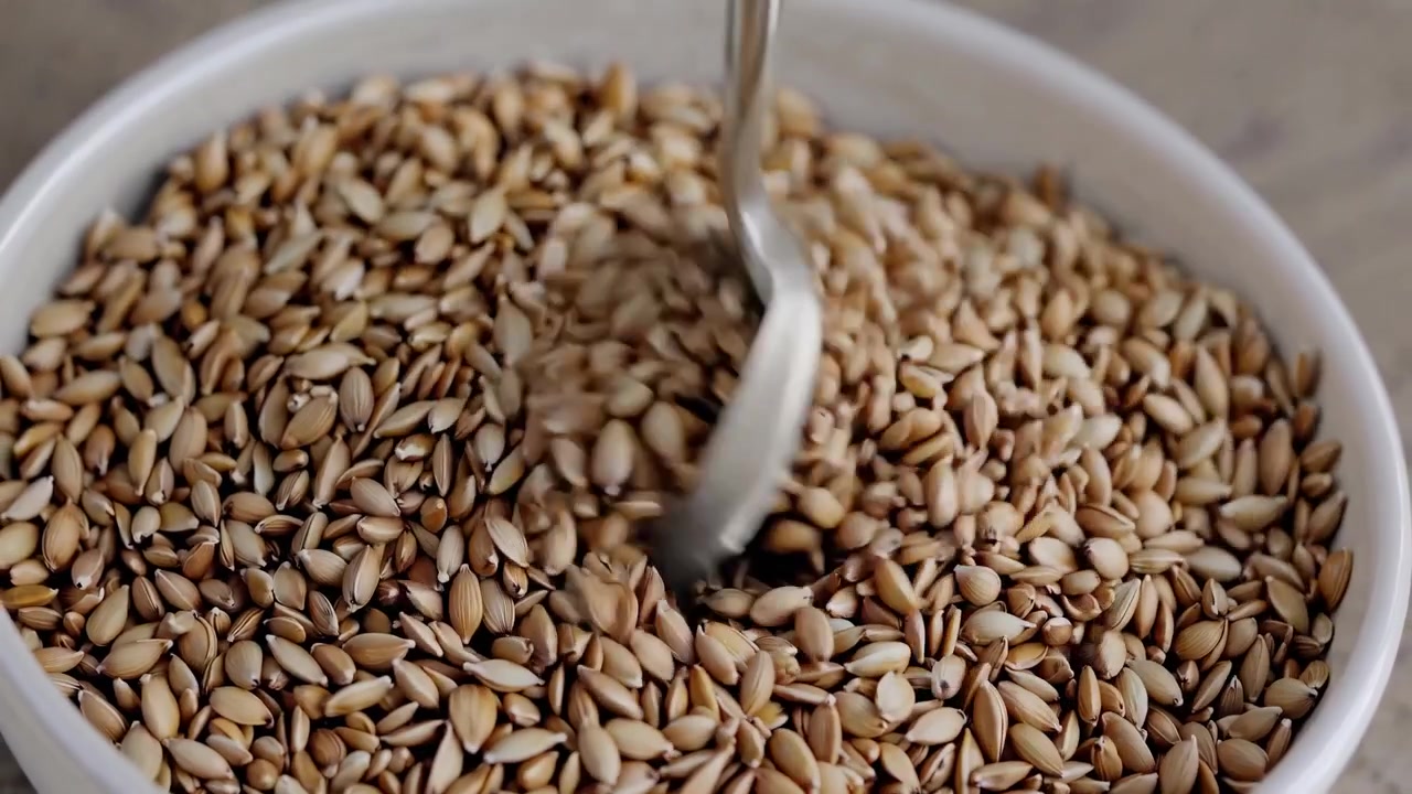 Cucchiaio che mescola cereali sani in una ciotola bianca