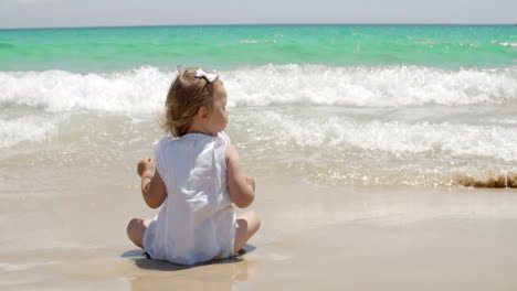 cute young girl paddling in the surf