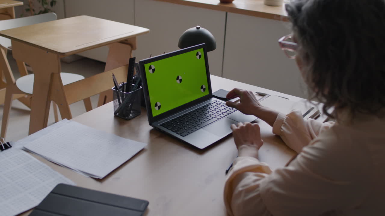 Woman using laptop in a classroom