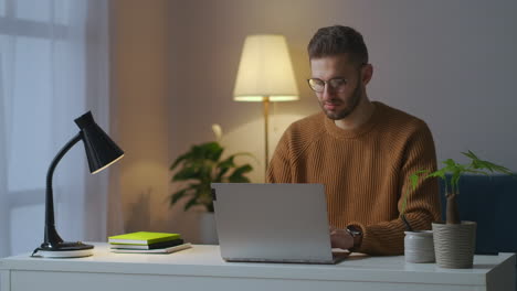 Internetnutzer-Arbeitet-Abends-Im-Wohnzimmer-Seiner-Wohnung-Mit-Seinem-Laptop,-Surft-Im-Internet-Und-Tippt-Nachrichten-Und-E-Mails,-Ruhiges-Wochenende-Zu-Hause