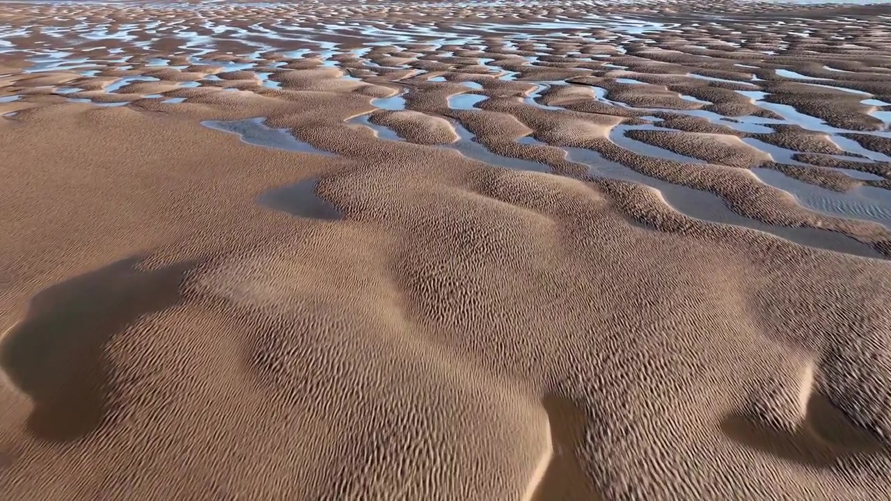 Motivi di sabbia ondulati e pozze di marea all'ora d'oro. Fleetwood, Lancashire, Inghilterra, Regno Unito.