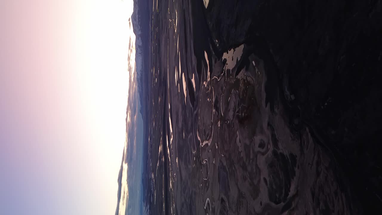 tomada vertical de avión no tripulado que muestra el lago argentino y el río con cielo púrpura por la noche