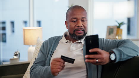 man using smartphone and credit card for online shopping at home