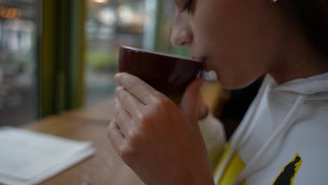 mujer bebiendo café en una cafetería