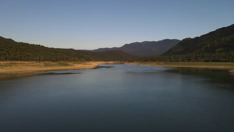 Panning-aerial-drone-footage-of-a-beautiful-and-calm-travel-destination-lake-located-between-a-serene-mountain-valley-in-northern-Spain