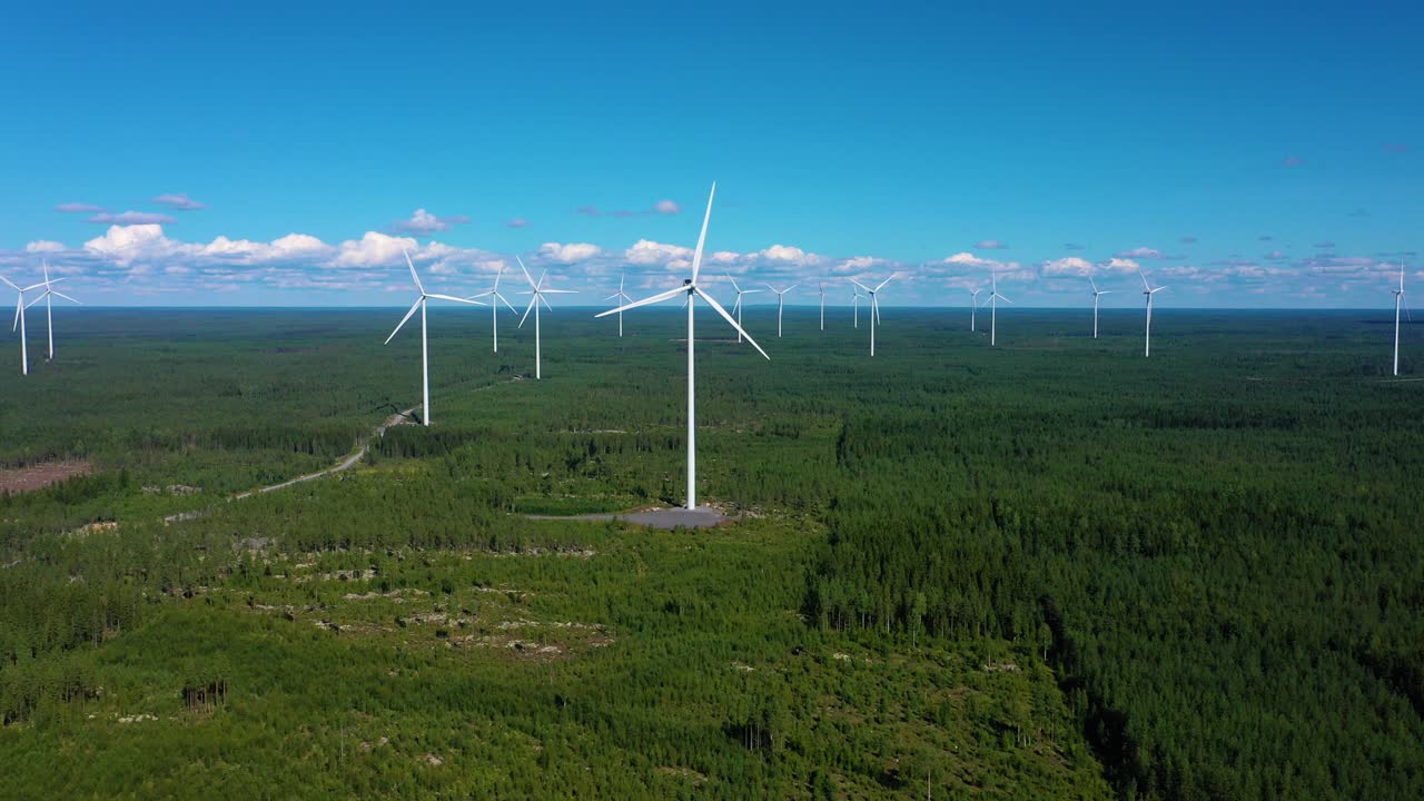 Aerial view of many windmills at a wind power farm, on a sunny, summer day, in Satakunta, Finland - Dolly, drone shot
