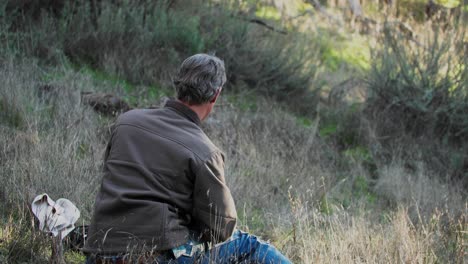 Hunter-Setting-Up-Game-Camera-on-Post-Near-Popular-Wildlife-Area