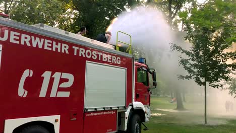 german firetruck spraying water for kids and trees on a hot summer day-7