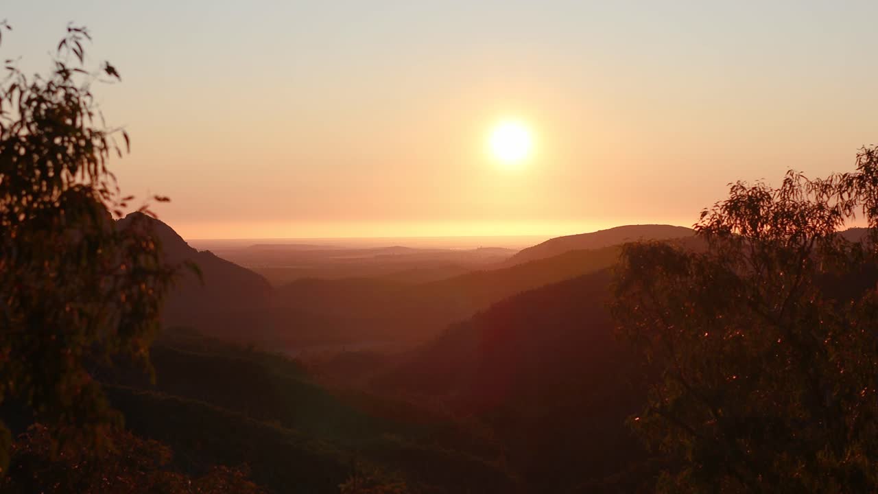 tempo do pôr-do-sol através de um horizonte montanhoso