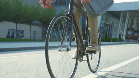 good looking  man riding a bike close to a building