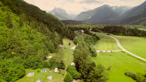 aerial view of a summer camp with tents located in a valley near the soca river.