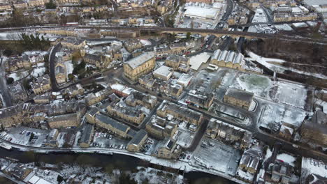 a snowy town centre scene with natural light and traffic , snow covered after a heavy fall todmorden north west yorkshire drone footage