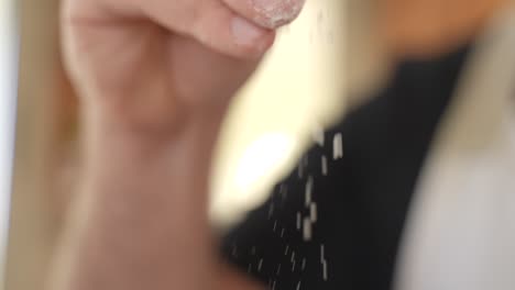 pastry chef scatters flour with fingers, isolated view on hand with copy space