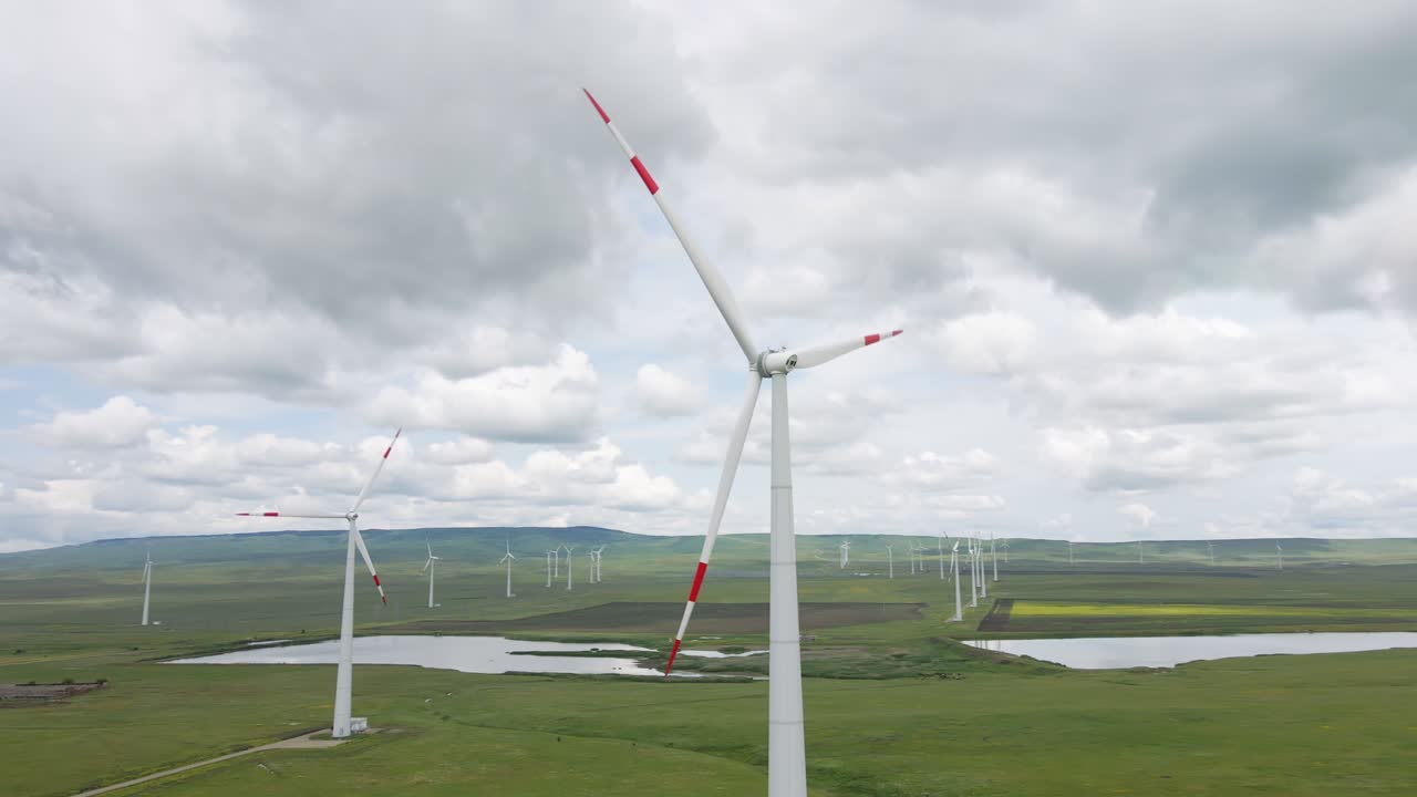풍력 터빈과 드론 비행은 풍력 발전소의 발전기를 둘러싸고 있습니다.