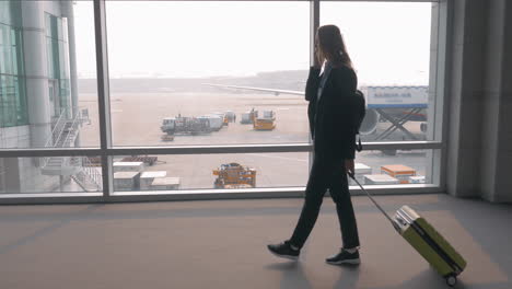 woman talking on mobile in airport terminal