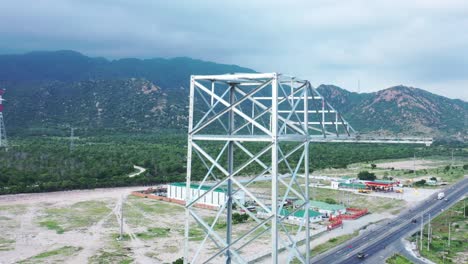 imágenes aéreas de drones de torres eléctricas de alta tensión con aislantes de vidrio prefabricados para distribuir electricidad en un parque industrial - concepto de desarrollo y urbanización