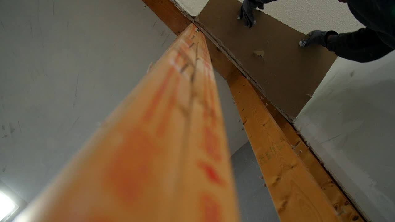 el hombre quita los paneles de yeso mientras los escombros caen en cámara lenta