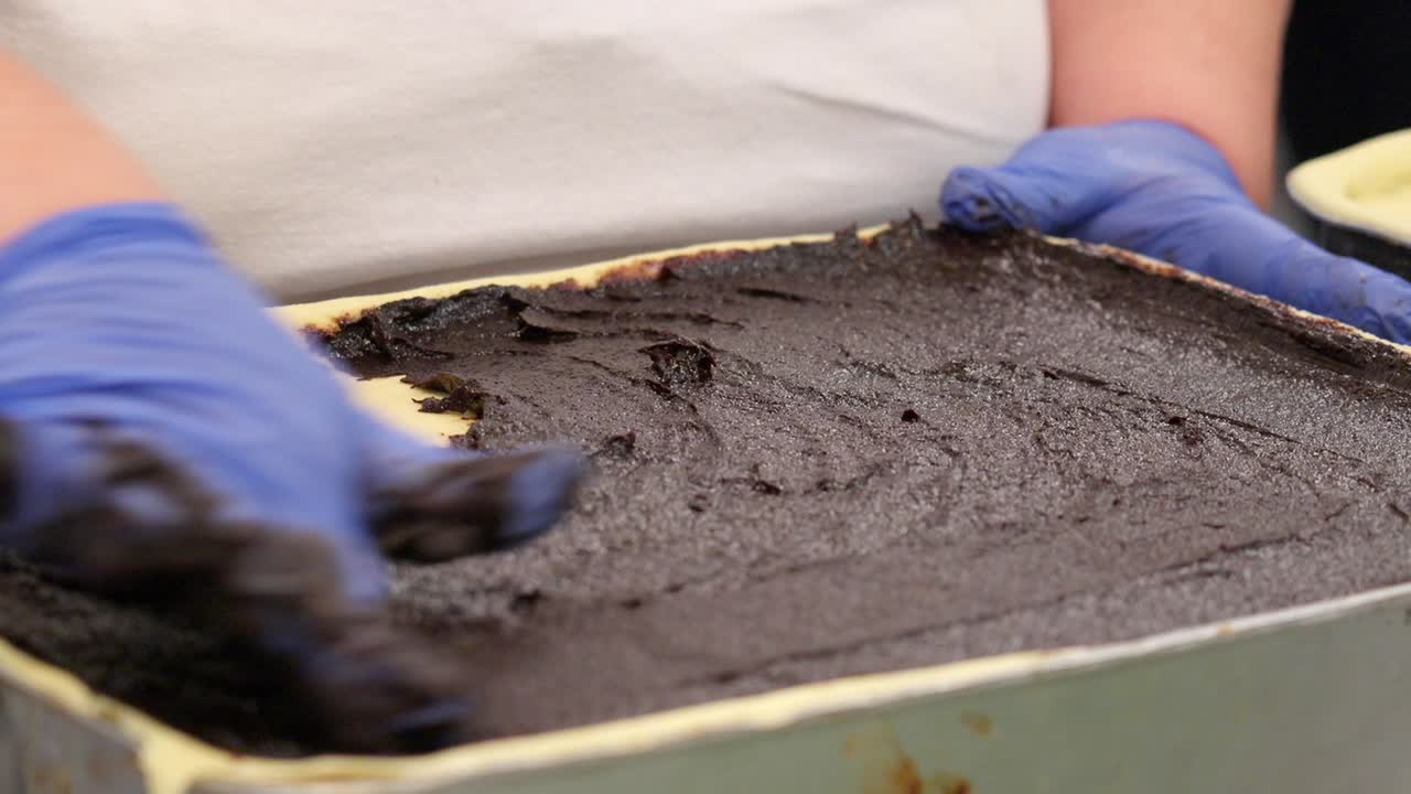 Aggiunta di ripieno al cioccolato su uno strato di pasta.