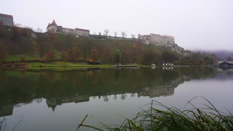 burghausen castle in the mist, slow panning shot revealing the longest castle in the world reflected in a lake