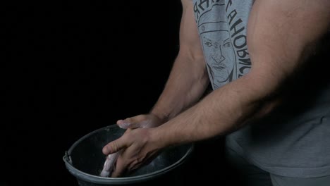 athlete preparing hands with chalk for a weightlifting exercise