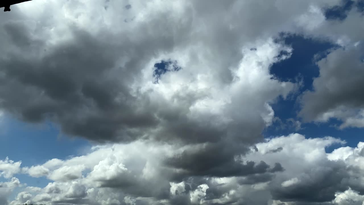 Grey clouds move quickly through the sky, penetrating clouds change shape and colour