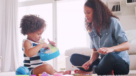 joven negra y su hija tocando instrumentos
