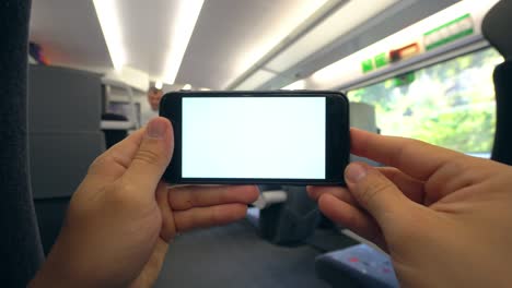 manos sosteniendo un teléfono con una pantalla blanca en el tren