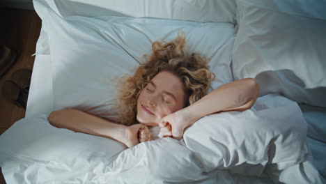 carefree girl stretching morning waking up from sleep. closeup happy lady in bed