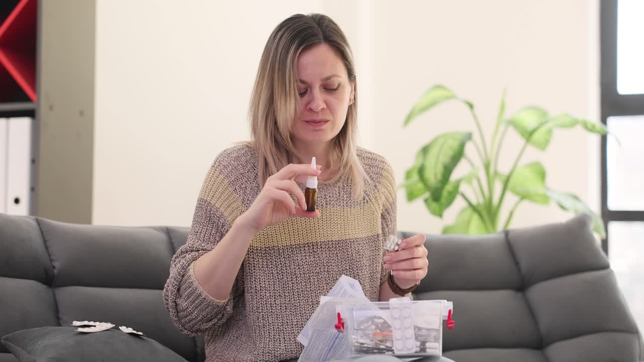 Woman using nasal spray and organizing first aid kit