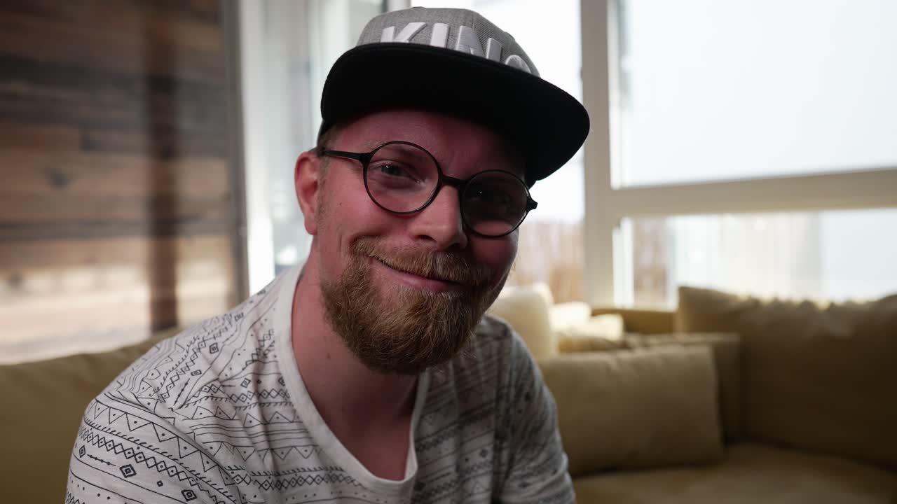 el hombre con gafas se da vuelta y sonríe a la cámara, asiente con la cabeza y hace zoom.