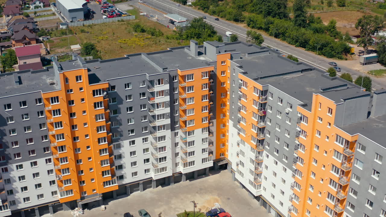 Block of flats in the city. Construction of a new apartment building. Modern high-raised building with colorful walls of residential complex.